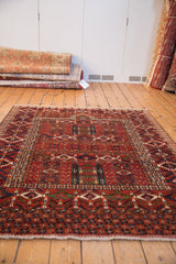 Cherry red and deep indigo geometric border with white fringe on a hand-knotted rug.