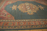 Vintage Indian Serapi Soumac rug detail: terra cotta border, serrated leaf motifs on abrashed teal.