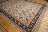 Vintage Serapi design carpet corner with intricate navy border and terra cotta floral motifs.
