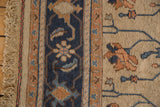 Hand-woven Indian Soumac rug edge showing natural fringe, navy border, and beige field with floral vinery.