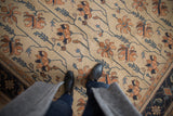 Vintage Indian Soumac carpet's Serapi pattern in ivory, terra cotta, and navy, underfoot.