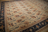 Detailed Serapi design of germinating plants, terra cotta floral petals, ivory field, navy border.