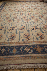Vintage Indian Soumac carpet's beige fringe and navy Serapi border with terra cotta floral vinery.