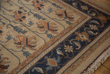 Detailed navy blue border, beige field with Serapi vinery on vintage Indian Soumac rug.