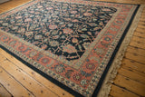 Vintage Soumac rug corner: dusty blush border, intricate palmette vinery, natural fringe.