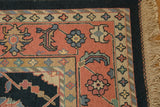 Rug corner with intricate palmette vinery on dusty blush field, navy border, and fringe.