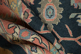 Hand-woven pile close-up, revealing intricate vinery and palmette motifs in dusty navy, blush, and ivory.