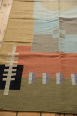 Geometric black, madder root red, sand, and faded royal blue blocks on a contemporary kilim.