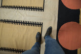 Contemporary Kilim carpet's abstract ivory, black, and terra cotta geometric patterns.