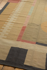 Flat-weave texture of charcoal and beige abstract design on contemporary kilim corner.