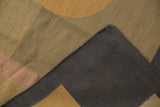 Hand woven Kilim rug folded, showing charcoal reverse, patterned beige face, and selvage.