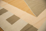 Geometric diamond pattern of the contemporary Kilim carpet in bronze, sand, and ivory.