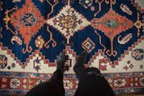 Vintage Northwest Persian carpet medallion detail with ivory, saffron yellow, and rust motifs on abrashed navy.