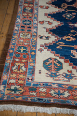 Northwest Persian rug detail: vibrant rust, navy, ivory floral border with white fringe.