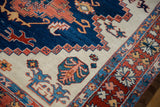 Vintage Northwest Persian rug detail showcasing navy, rust, ivory floral, and serrated leaf motifs.