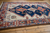 Corner of a vintage Northwest Persian carpet with intricate floral border and chocolate brown selvage.