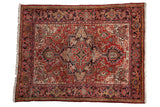 Vintage Heriz rug with a concentric geometric medallion in shades of cherry red and navy blue.