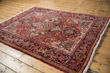 A vintage Heriz rug's classic geometric pattern and rich texture viewed from an angle.