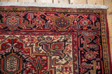 Detail of a vintage Heriz rug's navy border with red and powder blue geometric florals.