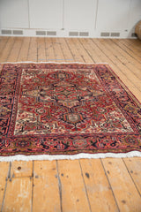 Angled view showing the traditional geometric pattern and rich texture of a vintage Heriz rug.