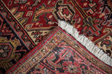 Detail of the hand-knotted construction and original fringe at the corner of a vintage Heriz rug.