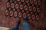 Plush charcoal pile and detailed gul medallions on vintage Bokhara rug.