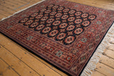Vintage Bokhara rug with repeating gul medallions, intricate geometric borders, and lustrous pile.