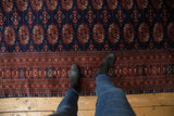Plush wool pile and detailed gul pattern on a vintage Pakistani Bokhara carpet viewed from above.