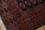 Intact ivory fringe and side cord on a vintage Bokhara rug with a plush navy blue and rust pile.