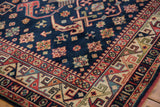 Colorful geometric main border and navy field with detailed diamond motifs of the Kuba rug.