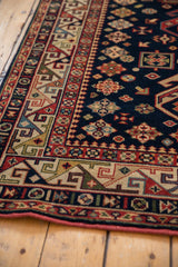 Colorful rhythmic geometric main border and playful diamond motifs on a navy Kuba carpet.