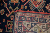 Vintage hand-knotted Kuba rug: navy geometric field, woven border, red selvage.