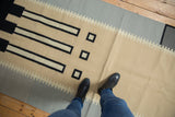 Abstract black and ivory geometric patterns on beige and slate vintage Kilim runner.