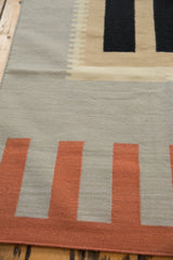 Abstract contemporary Kilim rug showing staggered lines in madder red and neutral tones.