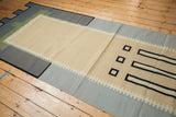Contemporary abstract kilim runner with ivory field, black linear motifs, and stepped border.