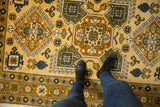 Vintage Caucasian rug's full pile with geometric hook motifs in saffron, blue, sage.