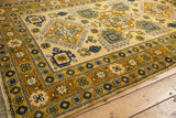Saffron yellow field and border, geometric hook and latch motifs in gold and denim blue.