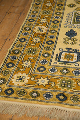 Vintage Caucasian carpet fringe and geometric border in saffron, gold, and denim blue.
