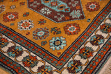 Vintage Kazak rug corner detail: ivory border, meandering vines, and colorful pawn motifs.