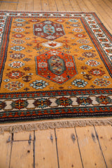 Beige border with colorful reciprocating pawn motif and tan fringe on the vintage Siberian Kazak rug.