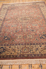Vintage hand-knotted rug's cream fringe and intricate navy, beige patterned border.