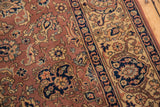 Hand-knotted field detail with navy blue palmettes, sand vinery, and lotus flowers.