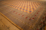 Detailed geometric border and plush, lustrous wool pile on a vintage tangerine orange Bokhara rug.