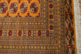 Finely woven corner of a Pakistani Bokhara carpet showing its detailed geometric border and ivory fringe.
