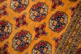 Detailed view of the Bokhara 'elephant footprint' medallions on the plush, tangerine orange wool pile.