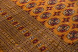 Finely knotted gul medallions and geometric border on a plush, tangerine orange Bokhara carpet.