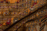 Soft folds in a vintage Pakistani Bokhara carpet showing its plush, tangerine orange wool pile.