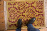 Embossed curvilinear Damask pattern with raspberry red and saffron yellow shades.