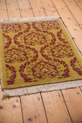 Embossed Damask pattern in saffron yellow and raspberry red, with neat ivory fringe.