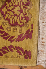 Embossed curvilinear Damask pattern featuring saffron yellow and pale raspberry red, with fringe.